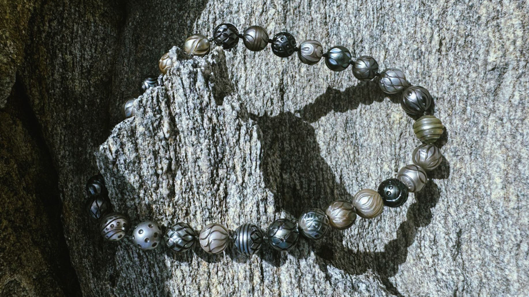 Hand-sculpted Tahitian Pearl necklace strand on a rock