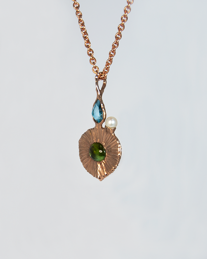 View of Nisi 18K Rose Gold Pendant on Green Tourmaline side with Blue Topaz and Freshwater Pearl