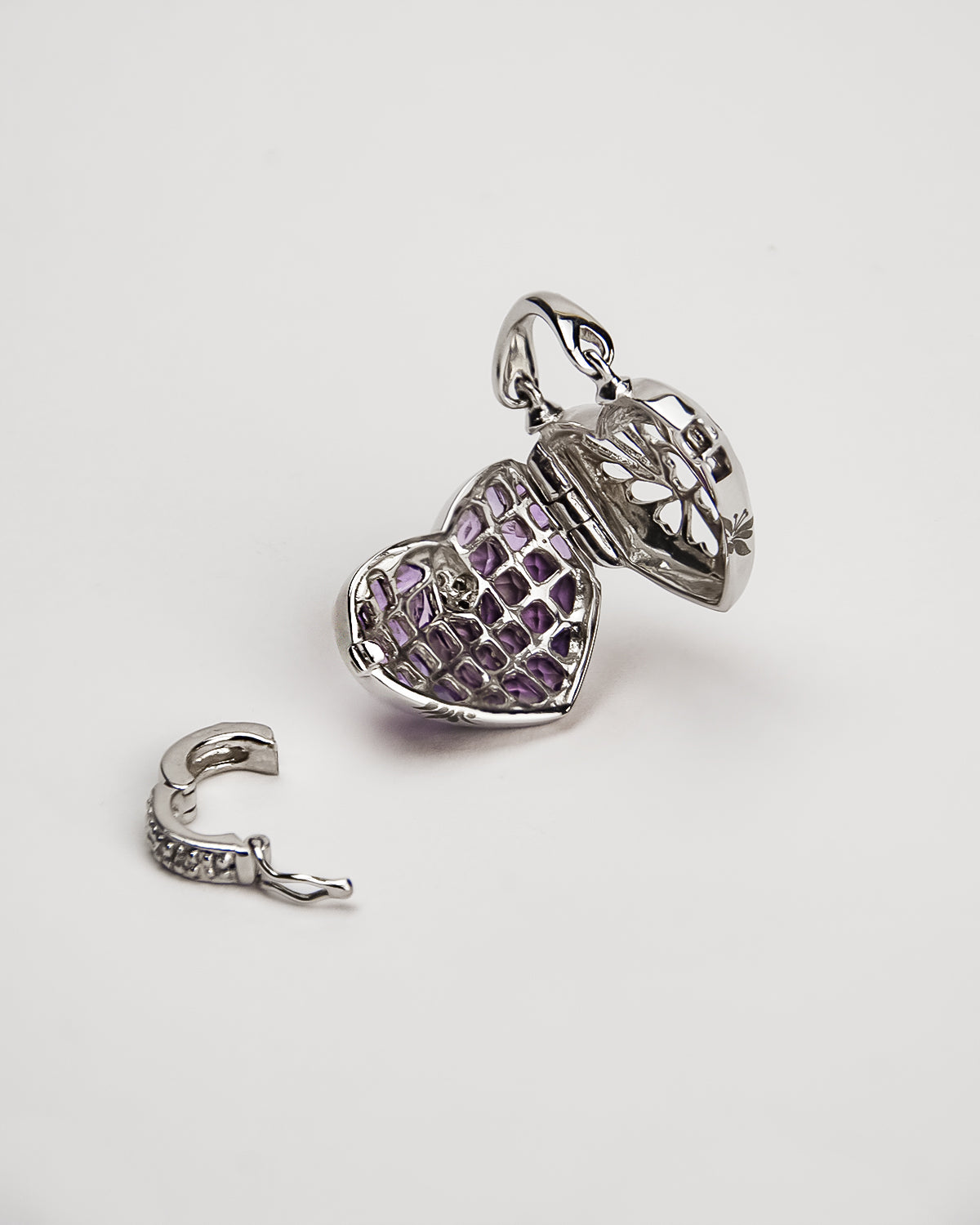 inside a white gold locket, highlighting its intricate detailing and removable clasp to attach the piece to different chains
