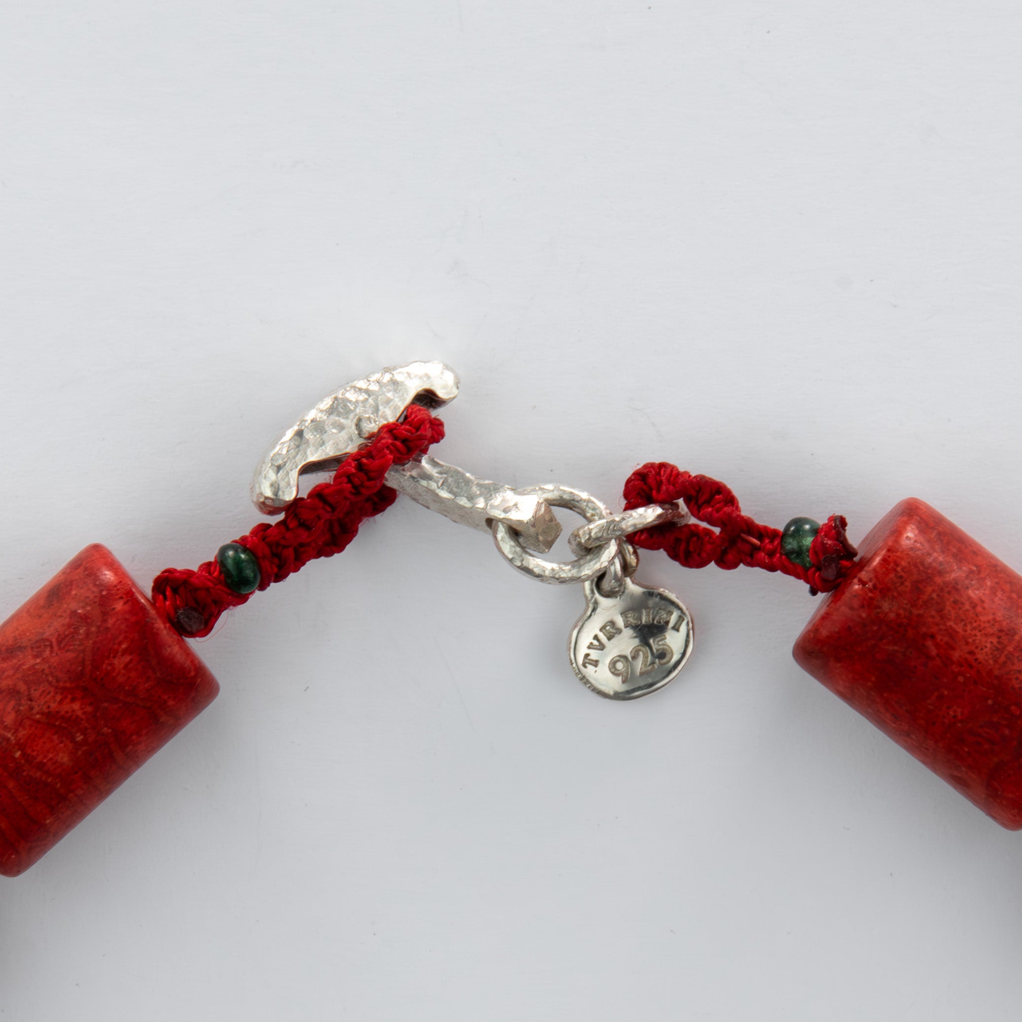 Close-up of a red beaded necklace with a silver clasp