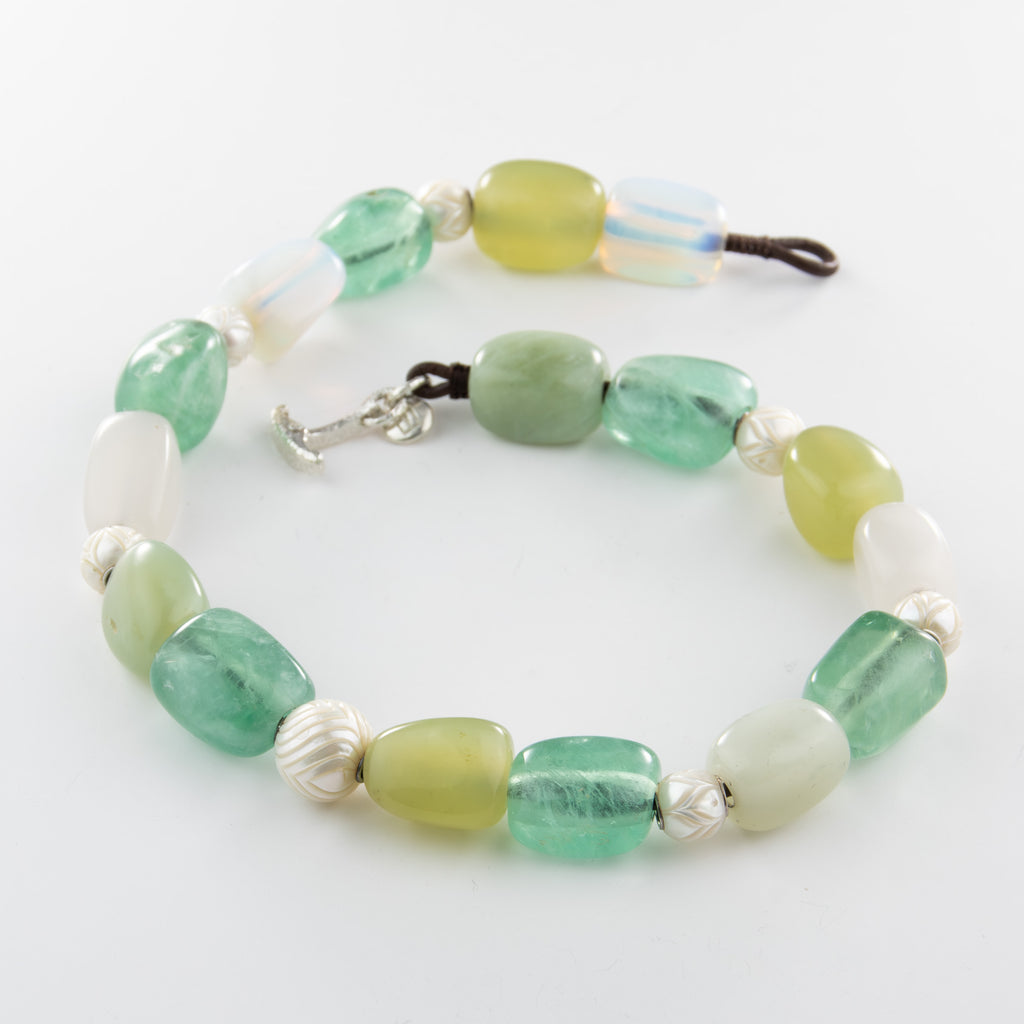 Necklace with green and white beads on a white background