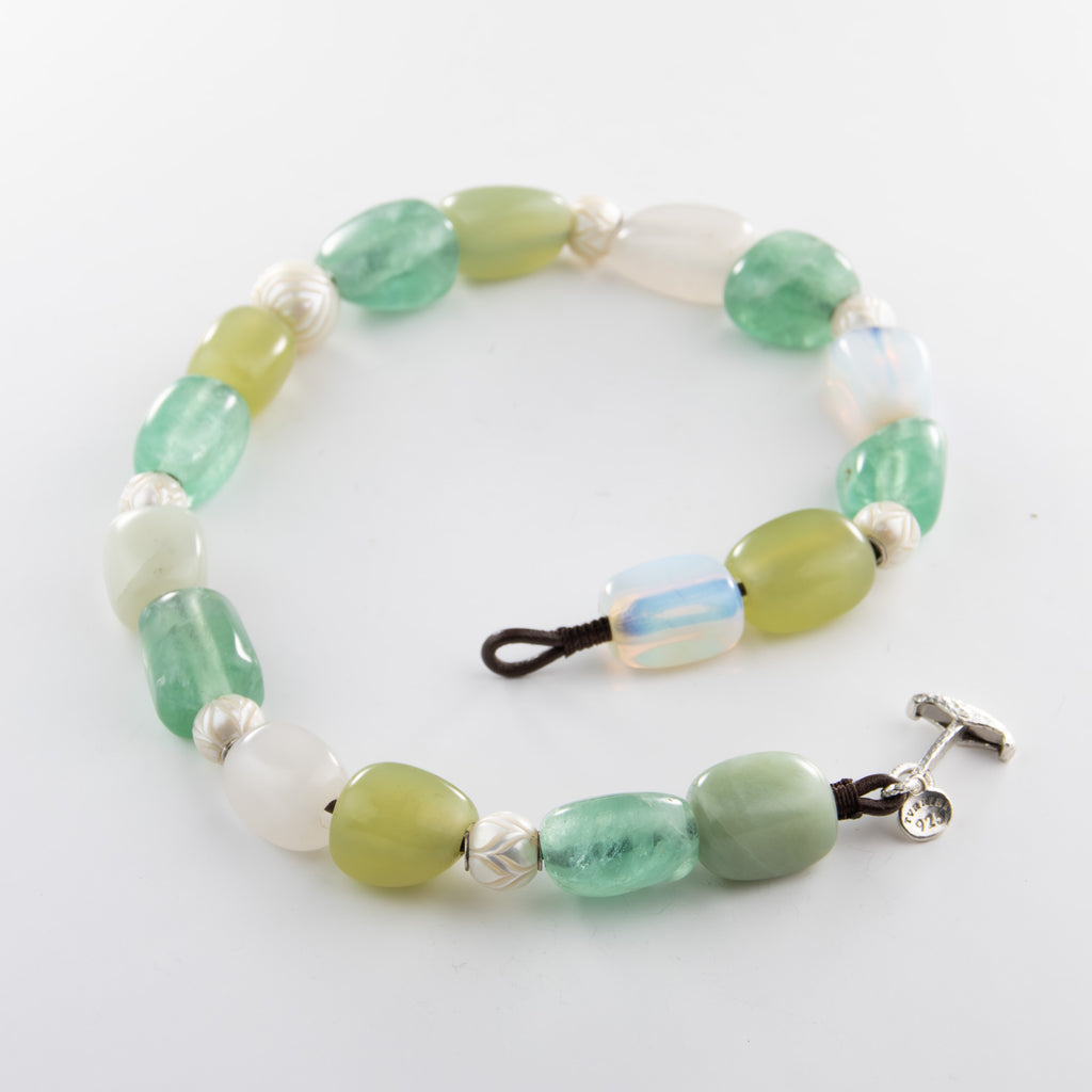 Beaded necklace with green and white beads on a white background