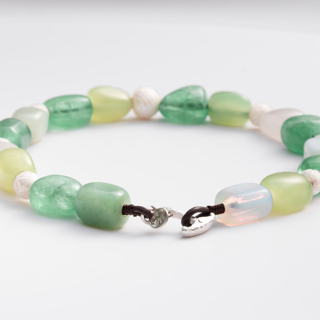 Necklace with green and white beads on a white background