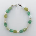 Necklace with green and white beads on a plain white background