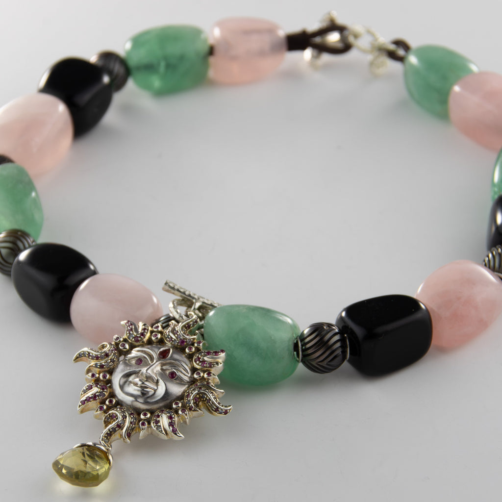 Necklace with multicolored beads and a decorative clasp on a light gray background
