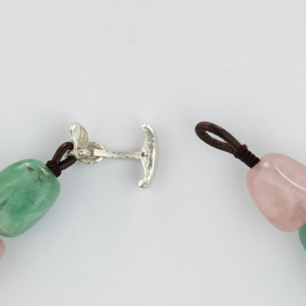 Close-up of a silver clasp and beads on a white background