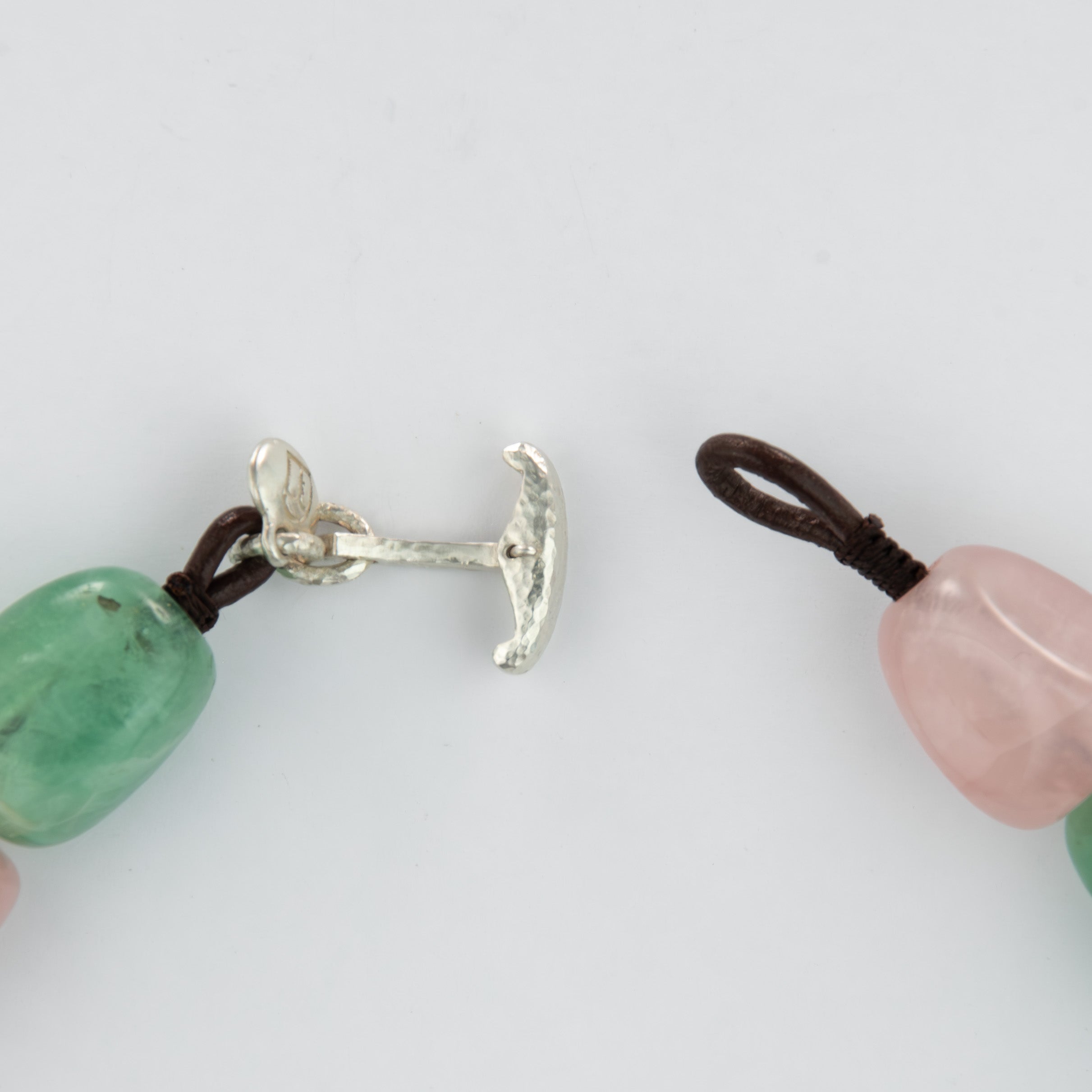 Close-up of a silver clasp and beads on a white background