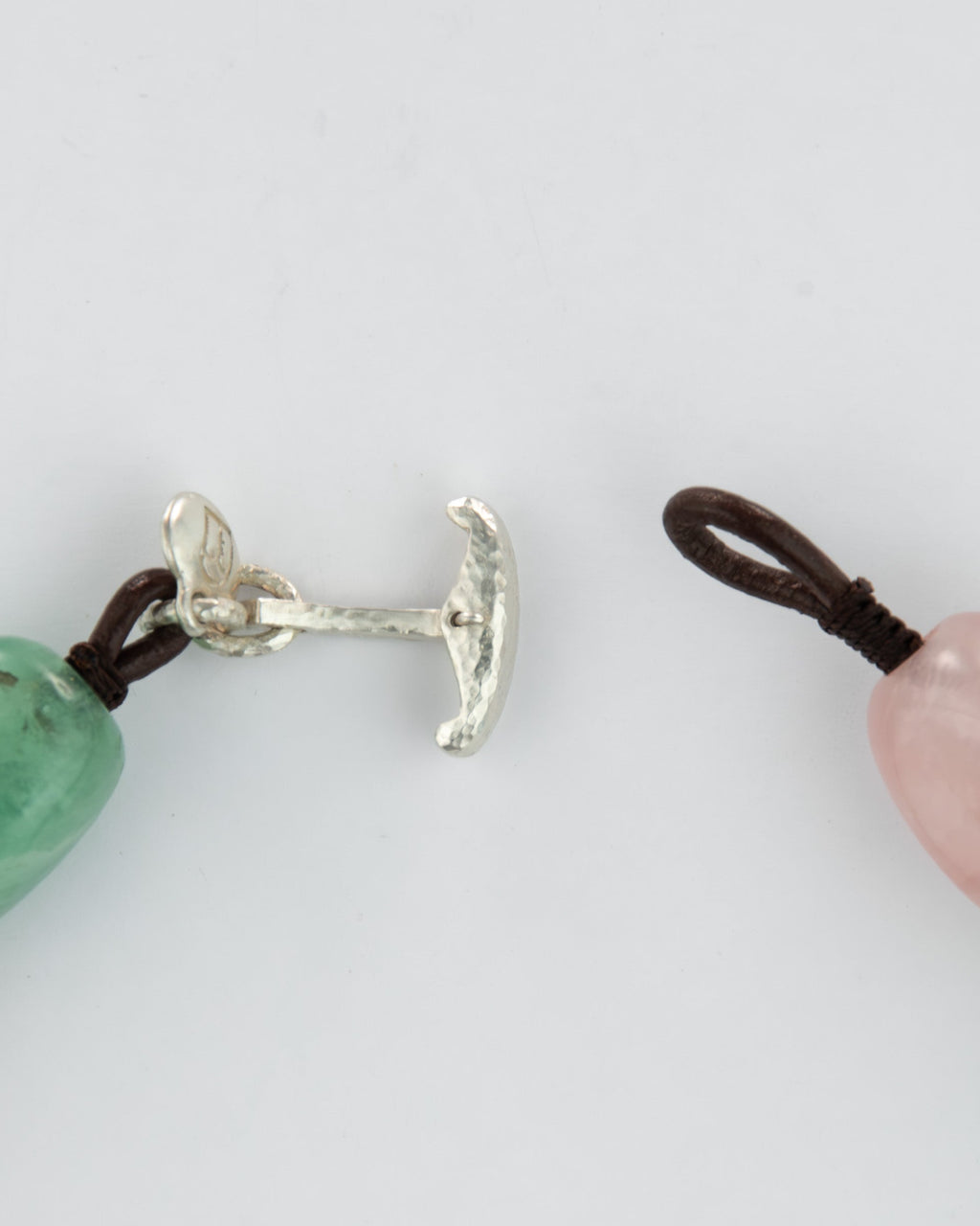 Close-up of a silver clasp and beads on a white background