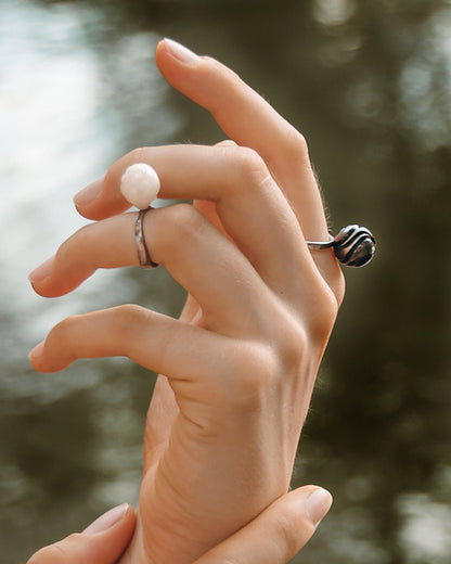 Model wearing Arched Metals black rhodium silver plated rings with handcrafted pearls