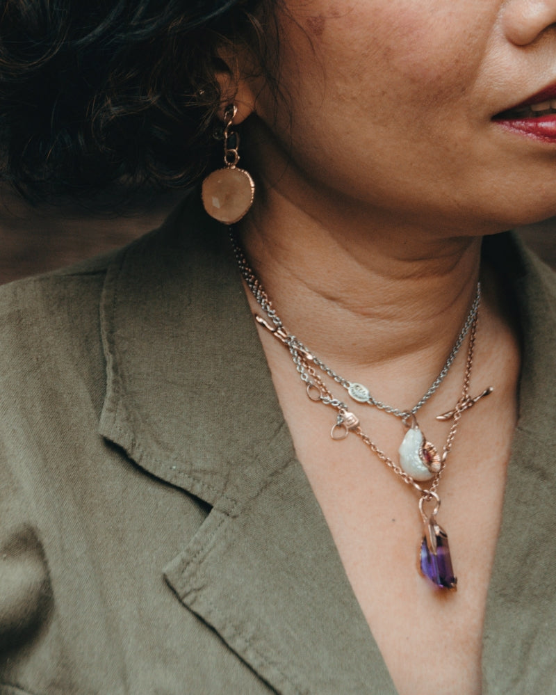 Outdoor session showcasing layered necklaces and earrings designed by TVRRINI.