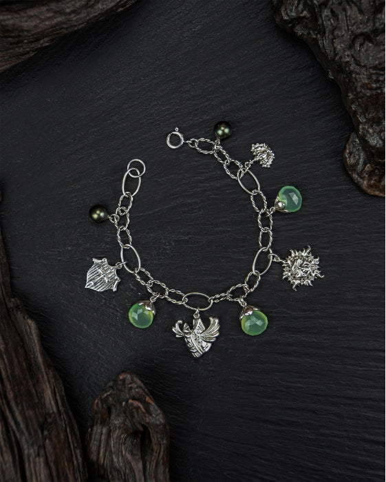 Charm bracelet on black slate and wood, designed by TVRRINI.