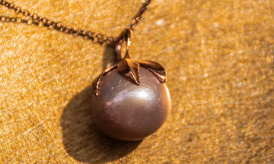 Kara Freshwater Pearl Pendant in Rose-Gold Plated Silver with a textured gold backdrop