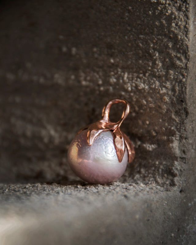 Kara 18K rose gold plated freshwater pearl pendant on concrete