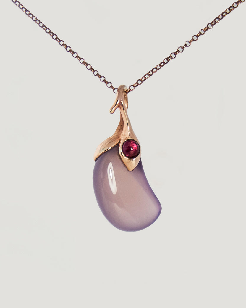 front side of a gold-plated silver pendant, featuring jelly bean-shaped purple chalcedony and pink tourmaline cabochon framed by free-form detail