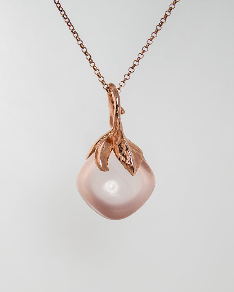 reverse of a pendant, highlighting the leaf-inspired setting that holds the rose quartz in place