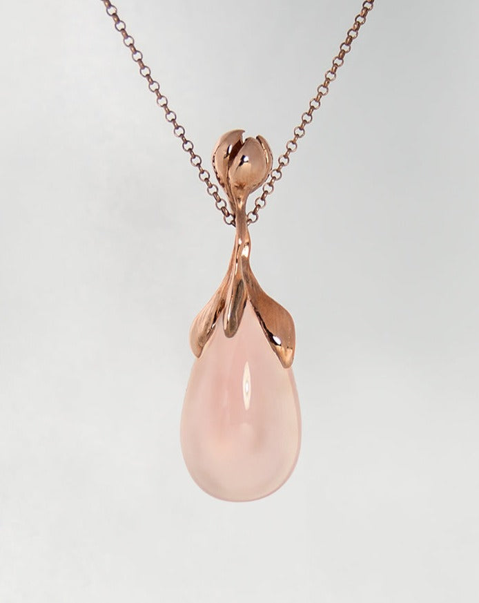 front view of a gold-plated silver pendant with a flower design, featuring a rose quartz teardrop cabochon