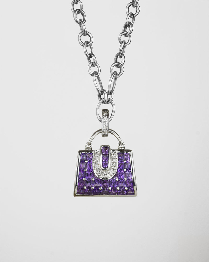 front of a 18K white gold with amethyst and diamond handbag locket pendant on signature TVRRINI chain