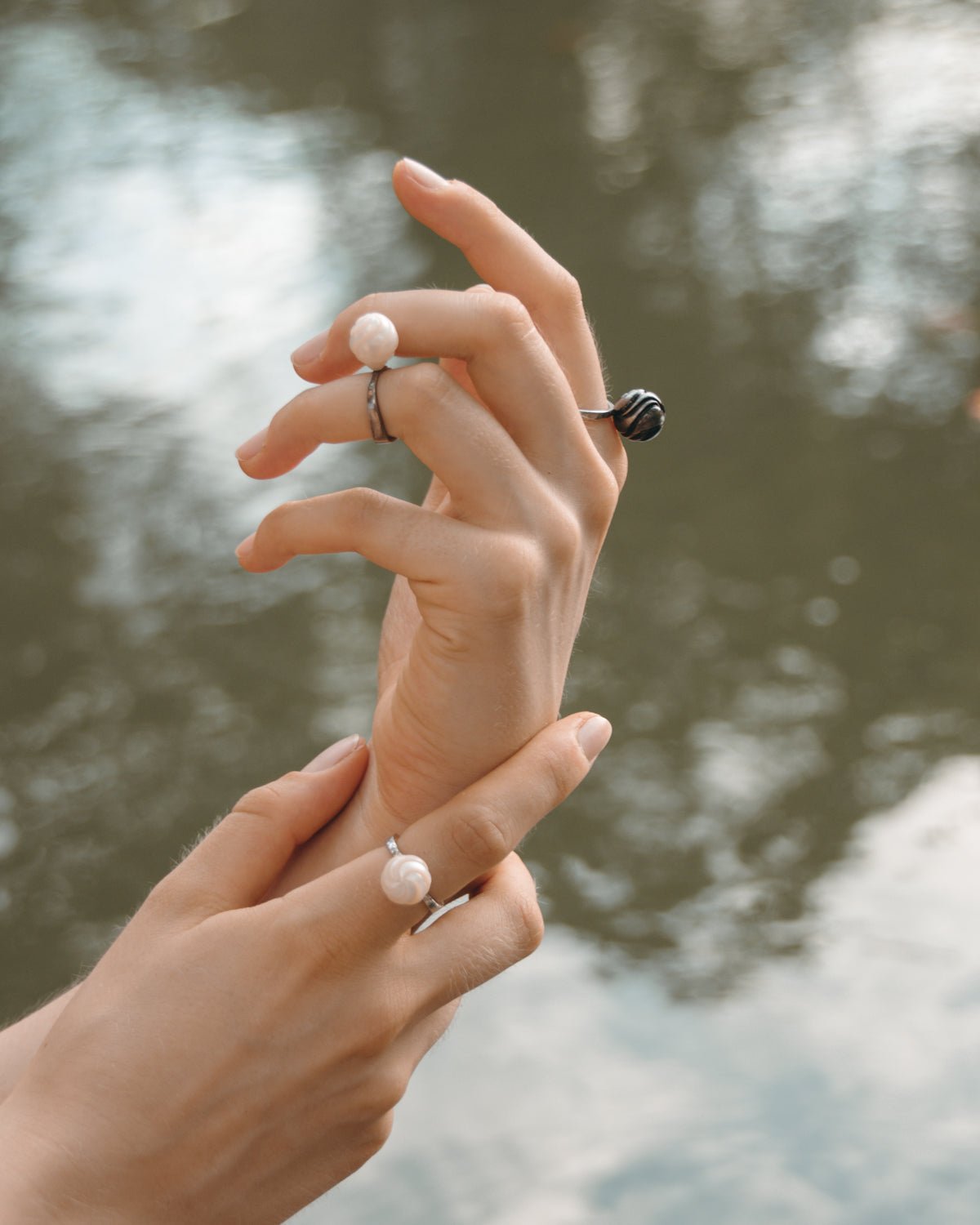 Model wearing selection of Arched Metals pearl sculpture rings