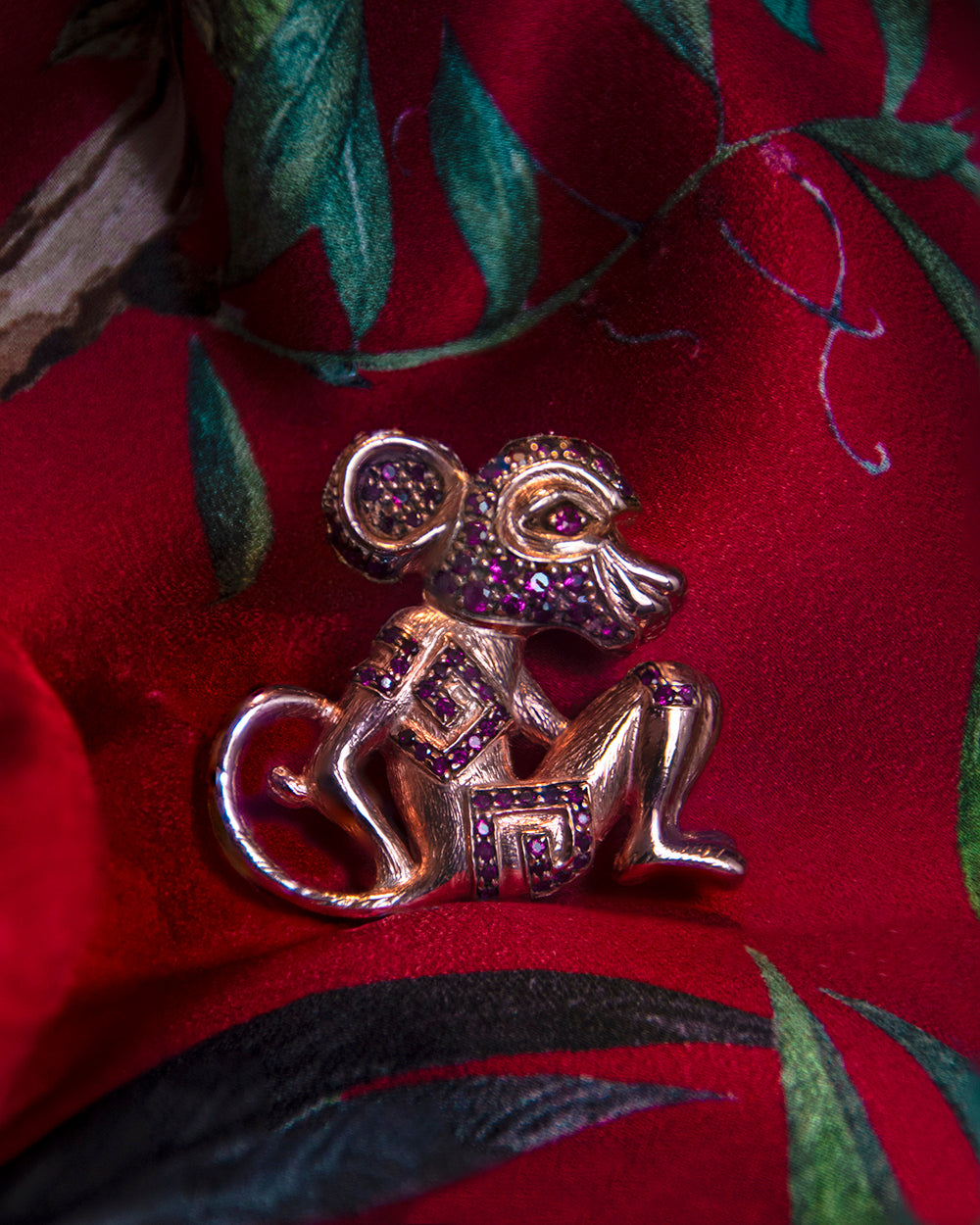 A sterling silver with 18K rose gold plating pendant, in the shape of a sitting monkey, set with rubies 