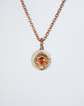 close-up of a rose gold-plated silver pendant with freshwater pearl and orange sapphire