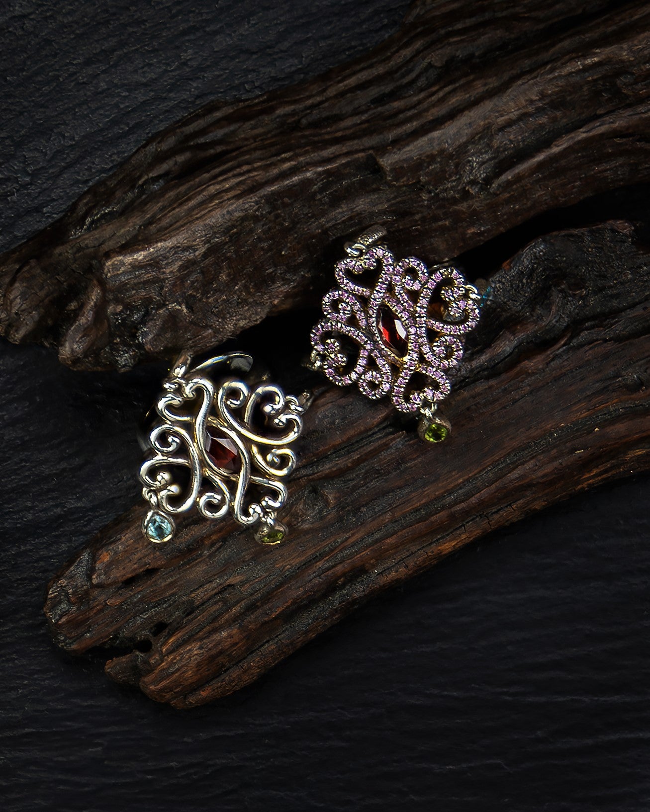 overhead view of two rings featuring coloured stones in a playful silver mount with smooth flowing lines