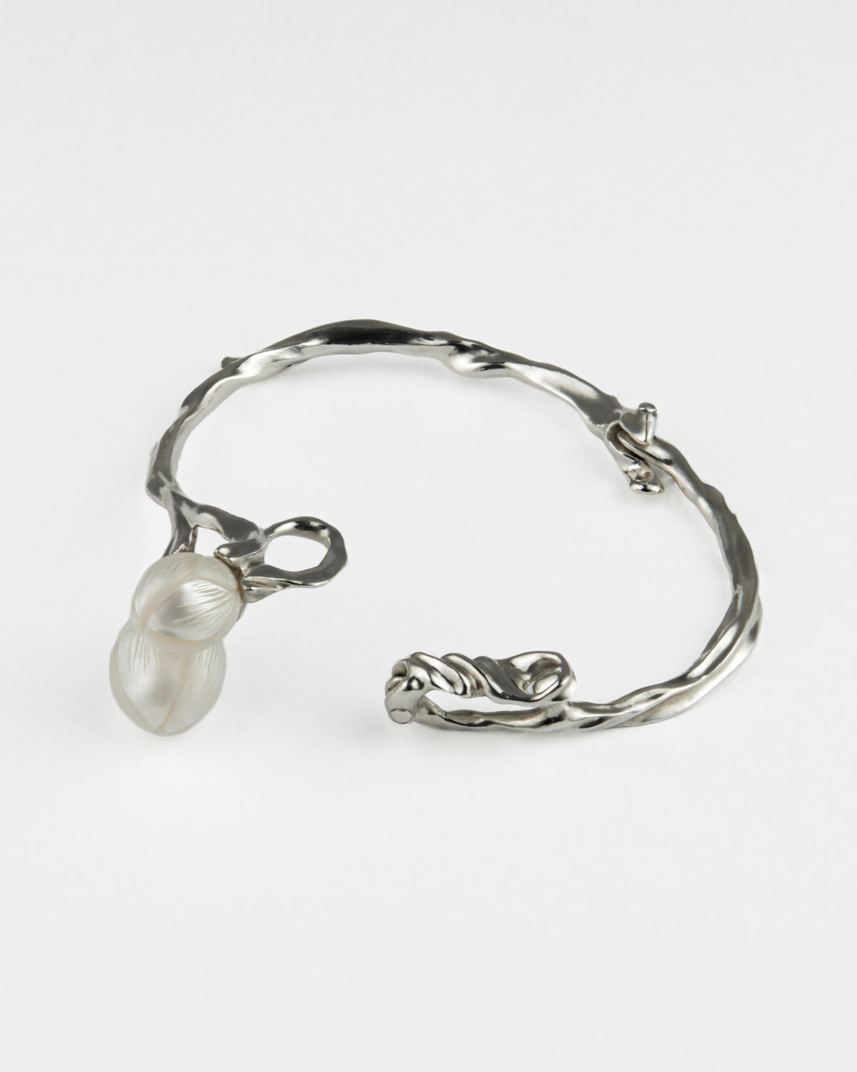 A silver twisted branch bracelet featuring two white freshwater pearls.