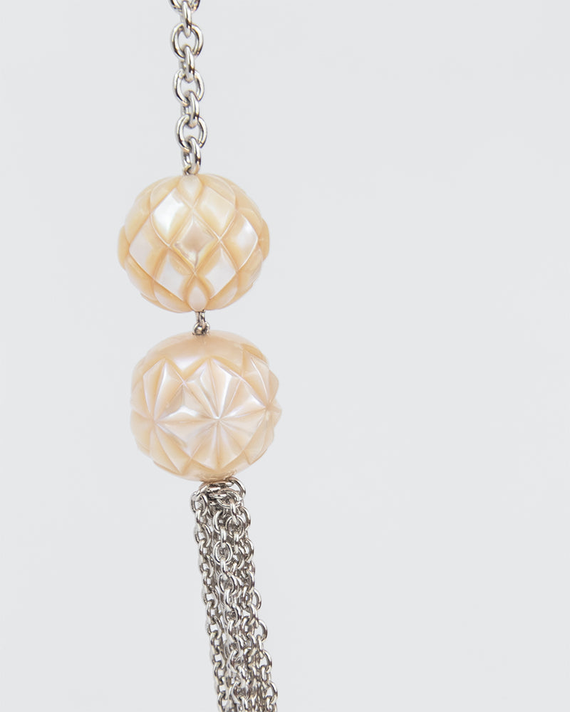 Close-up of two Freshwater Pearls set in a silver chain to showcase their elegant hand-crafted patterns