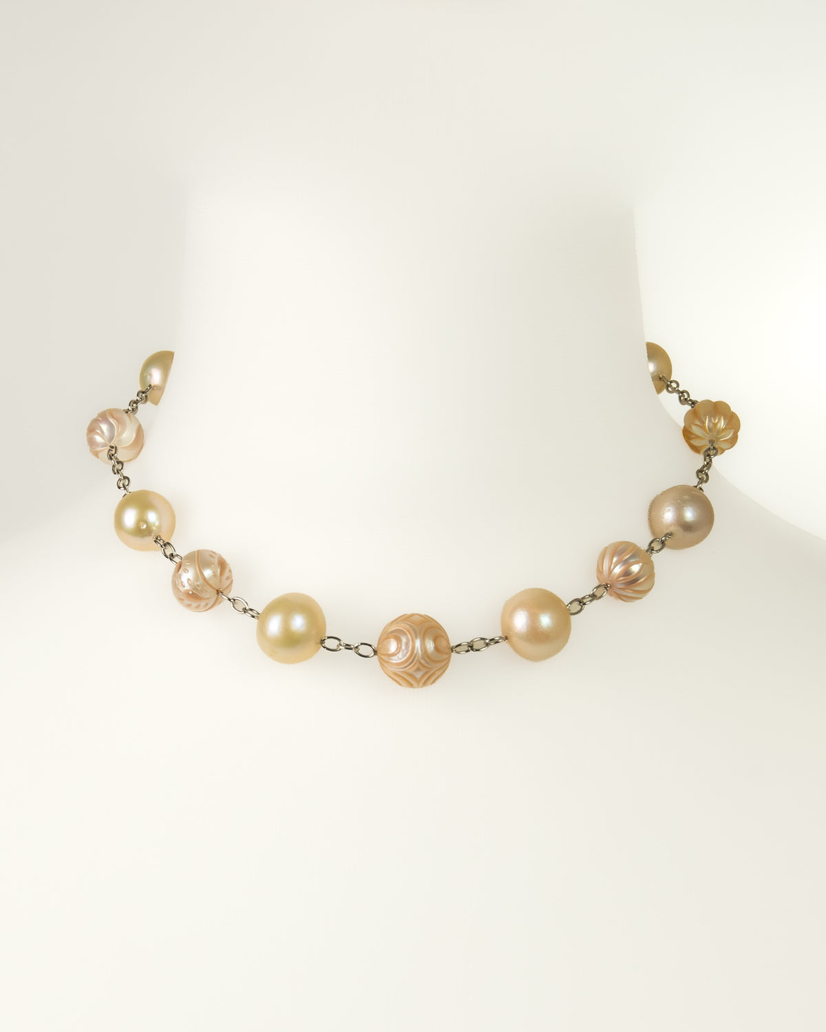Choker featuring large cream and pale gold pearls separated by small silver links.