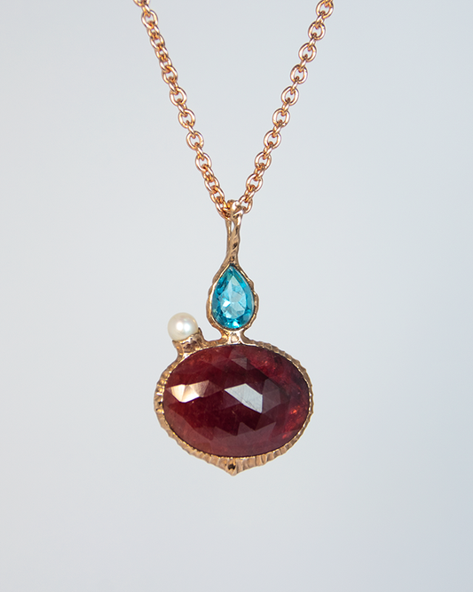 View of Nisi 18K Rose Gold Pendant on Ruby side with Blue Topaz and Freshwater Pearl
