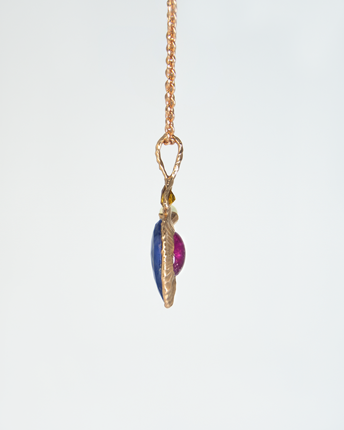 Side view of Nisi Vessel Pendant in 18K Rose Gold with Blue Sapphire, Rubellite, Citrine, and White Freshwater Pearl