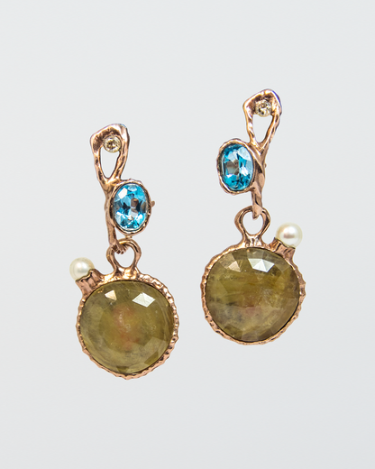 Signature Earring Pins with Blue Topaz and Dusty Diamonds holding Nisi Pebble Earrings