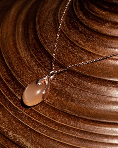 Editorial view of unique Kara Pendant with Oval Cabochon Peach Moonstone set in 18K Rose Gold on chain