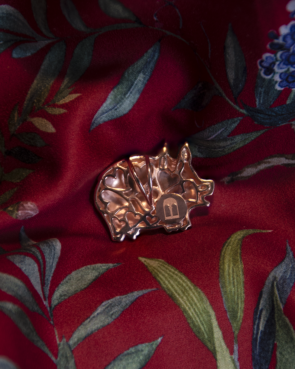 Back detail on Circle of Life Pig Pendant in 18K Rose Gold decorated with round faceted Ruby