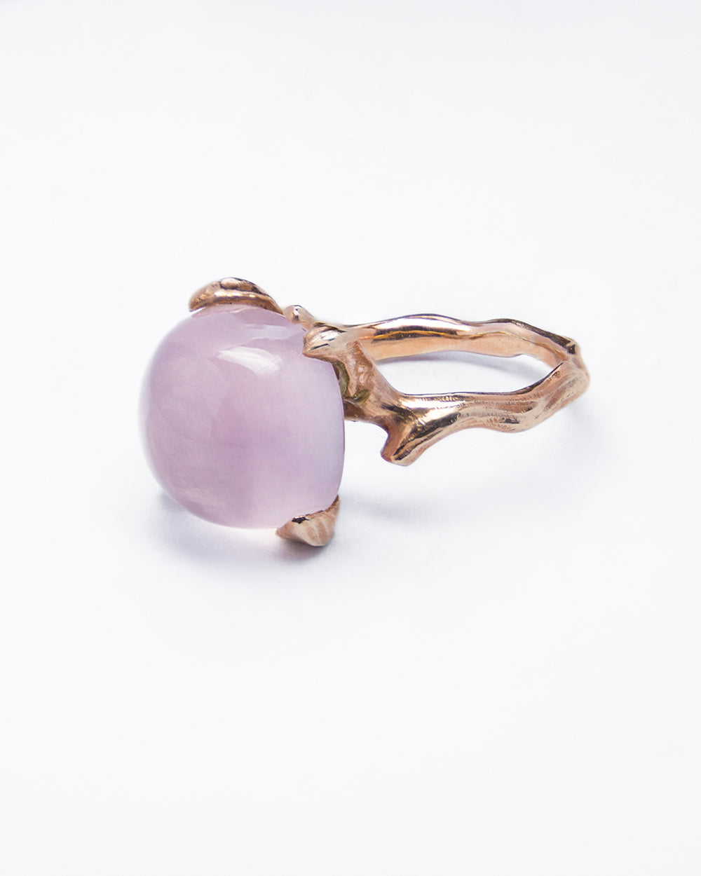 angled view of a ring featuring a square cabochon Rose Quartz set in a free-form gold-plated silver band