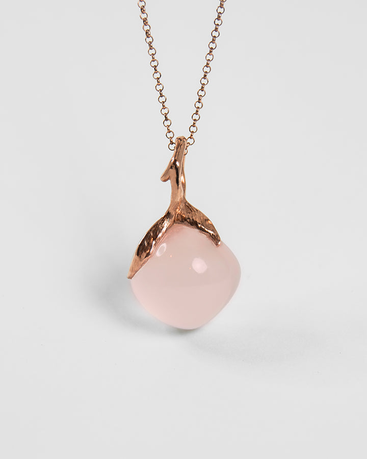A sterling silver pendant with rose gold plating, featuring the organic setting on a rose quartz square cabochon