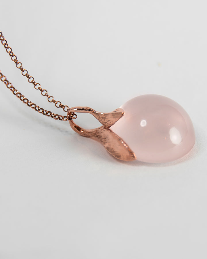 side profile of rose gold-plated sterling silver pendant, highlighting free-form setting of the rose quartz