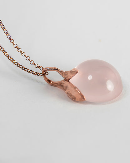 side profile of rose gold-plated sterling silver pendant, highlighting free-form setting of the rose quartz