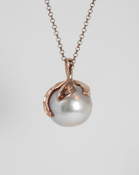 back of a pendant with a satin finish rose gold-plated silver setting that holds the pearl in place