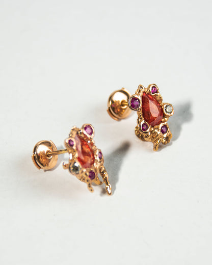 close-up of earring studs crafted from 18K Rose Gold set with Orange Sapphires, Rubies, and Diamonds