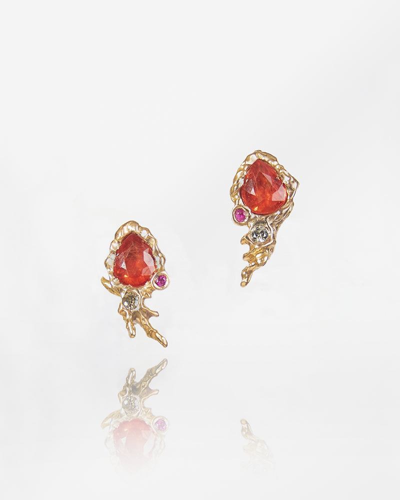 front view of earring studs featuring orange sapphires, rubies, and diamonds framed by 18K rose gold