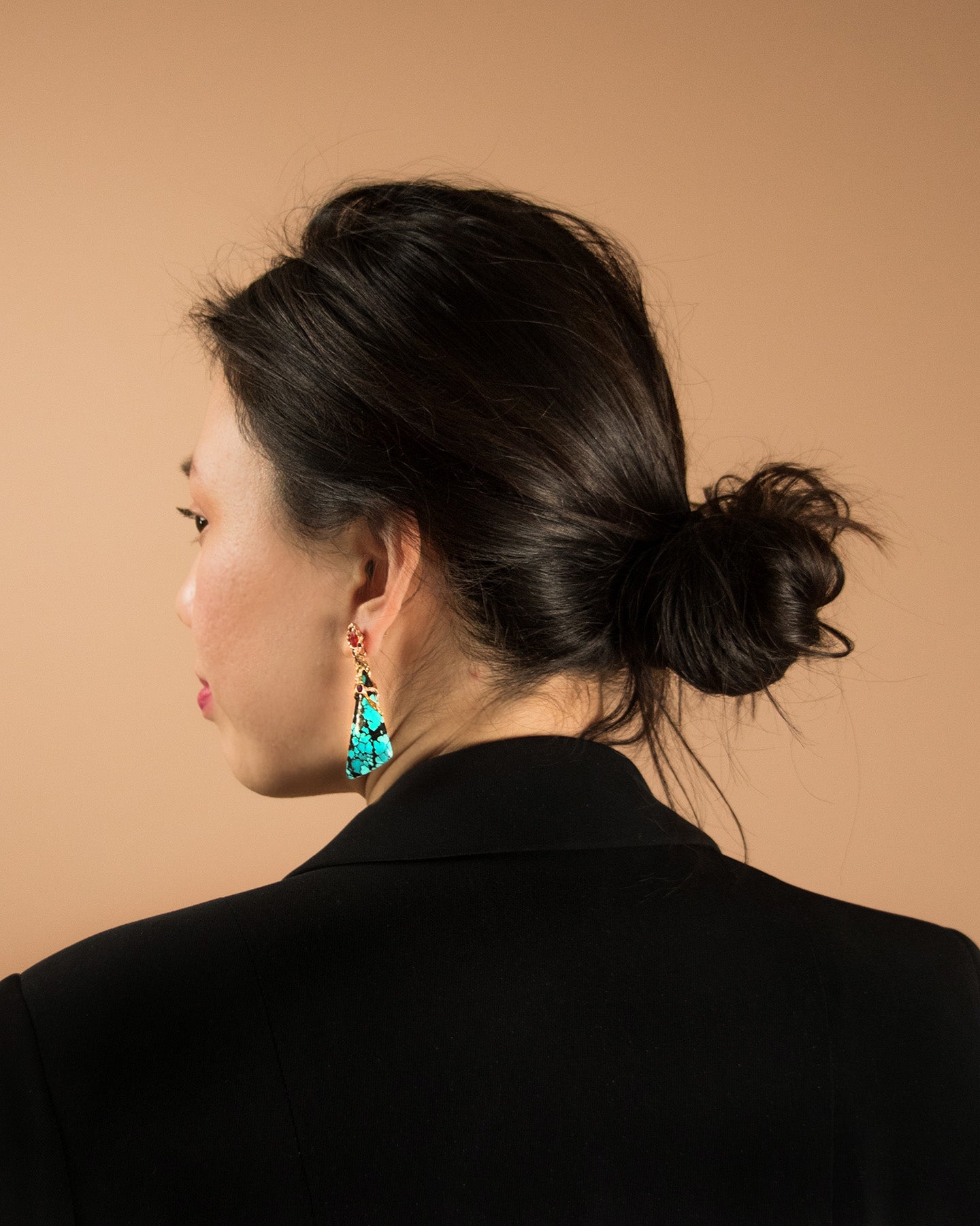 a side profile of a model wearing Lava earrings with studio lighting enhancing its colours