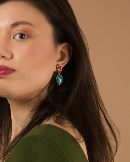 model wearing 18K rose gold earrings with a sculptural setting, featuring turquoise, orange sapphire, rubies and diamonds