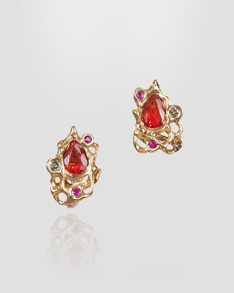 front view of earring studs featuring orange sapphire, ruby, and diamond in a sophisticated, abstract gold setting