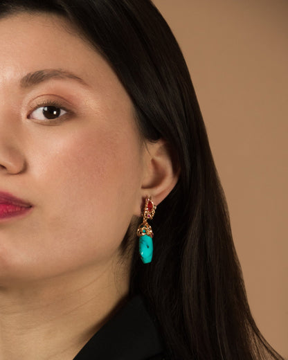 close-up of a model wearing 18K rose gold earrings with detachable drops