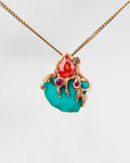 Front view of pendant with s free-form 18K gold setting, featuring turquoise, orange sapphire, ruby and diamond  