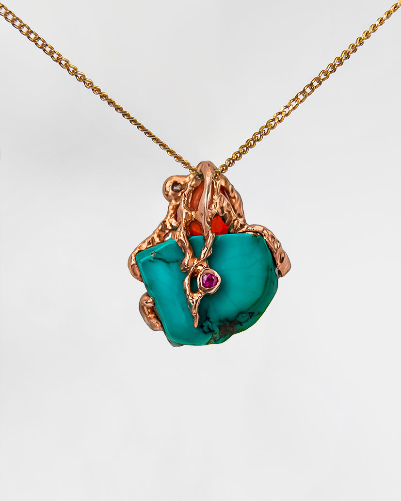 Back view of a pendant, highlighting its unique, free-form setting that holds a ruby