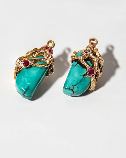 angled view of detachable earring drops featuring turquoise, rubies, and diamonds framed by molten 18K gold setting