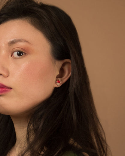 profile of model wearing 18K rose gold stud earrings with free-form setting, featuring orange sapphire, ruby and diamond