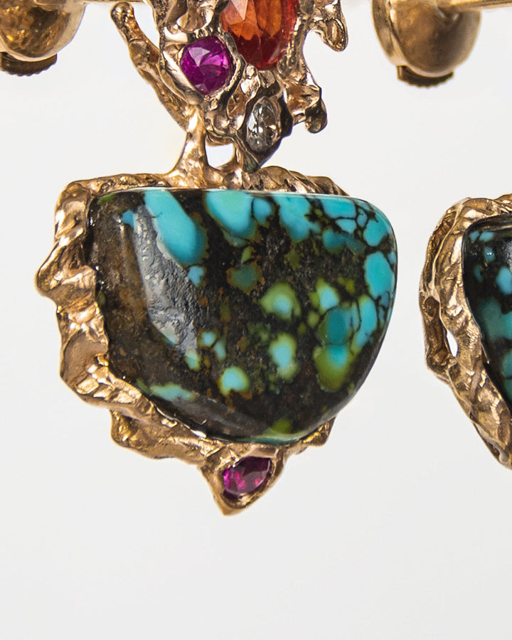 close-up of earrings with a free-form sculpted gold design, capturing the molten texture