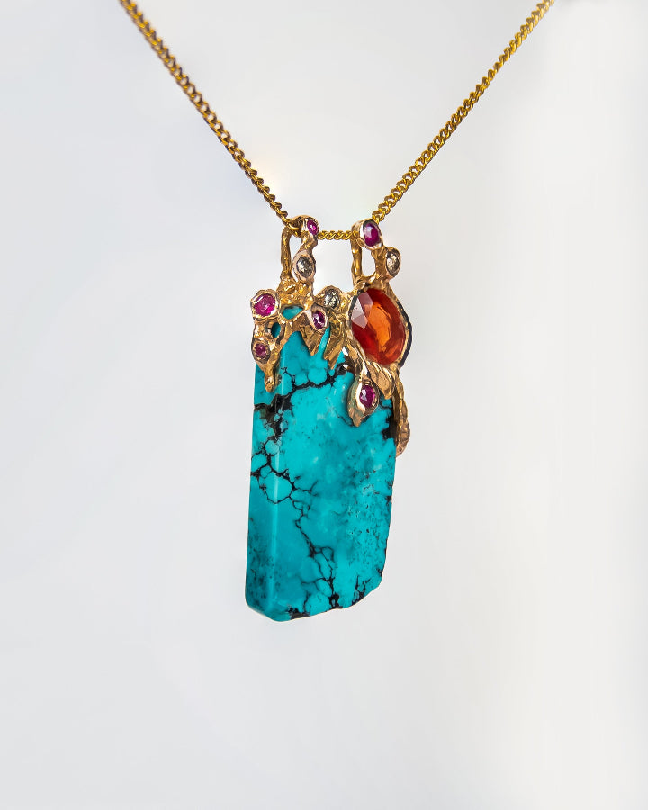 angled view showcasing gemtones are mounted on the side of a unique pendant